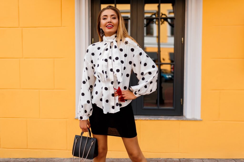 happy woman in stylish spring clothes with luxury bag posing on the street