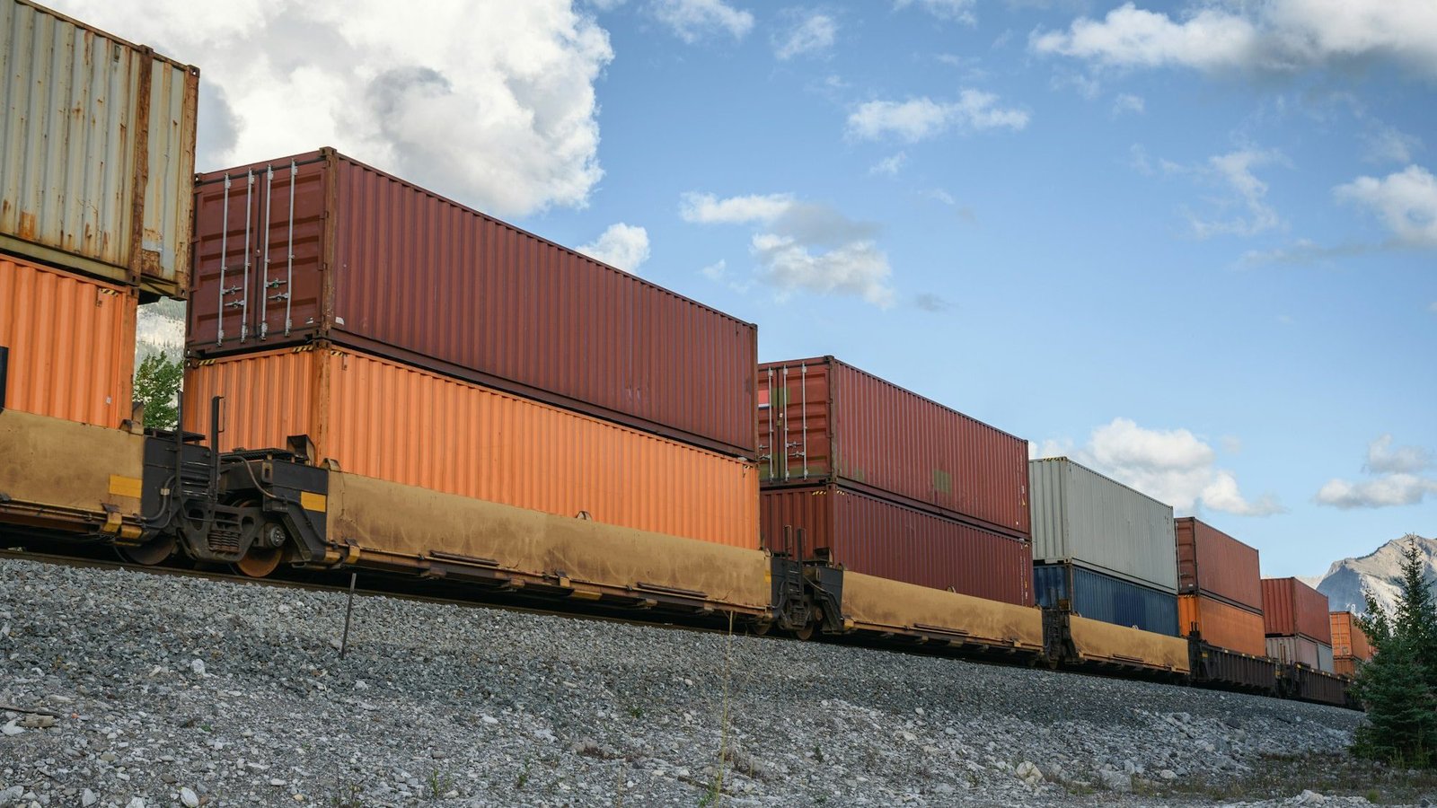 Train long freight passing with container loading on railway in valley